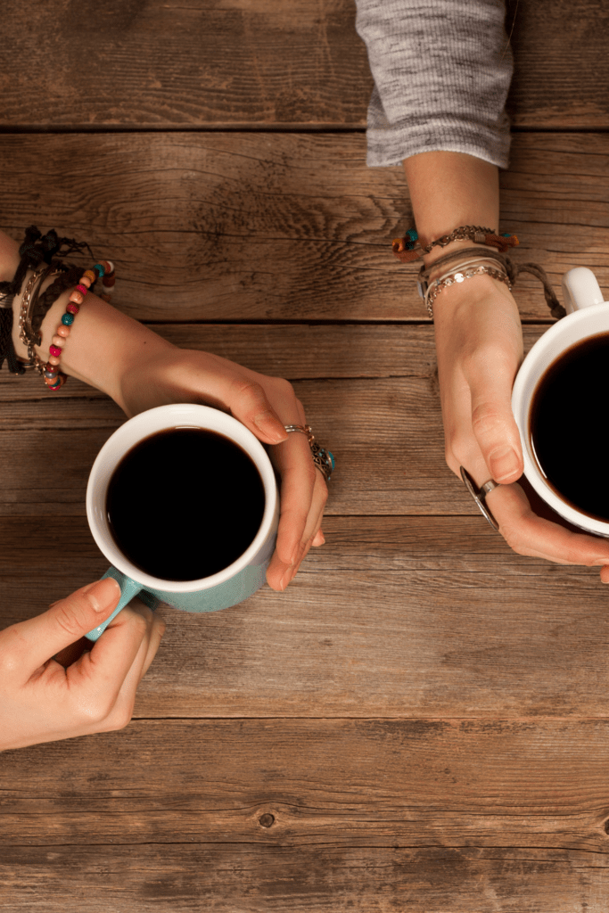 woman and man hand holding black coffee cups