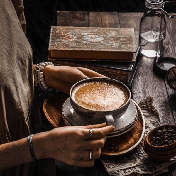 woman holding coffee mug on table with rings on