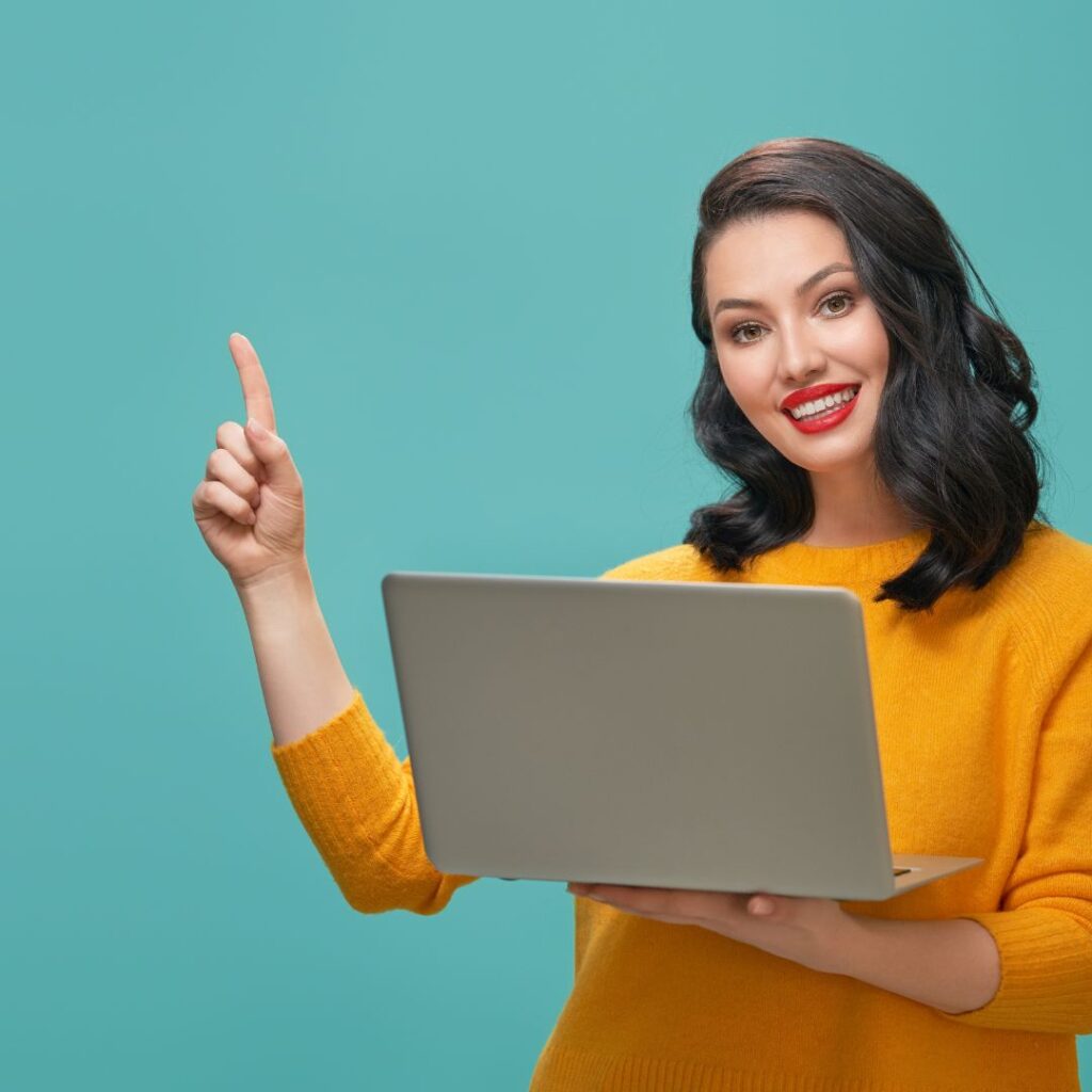 woman holding laptop with finger up