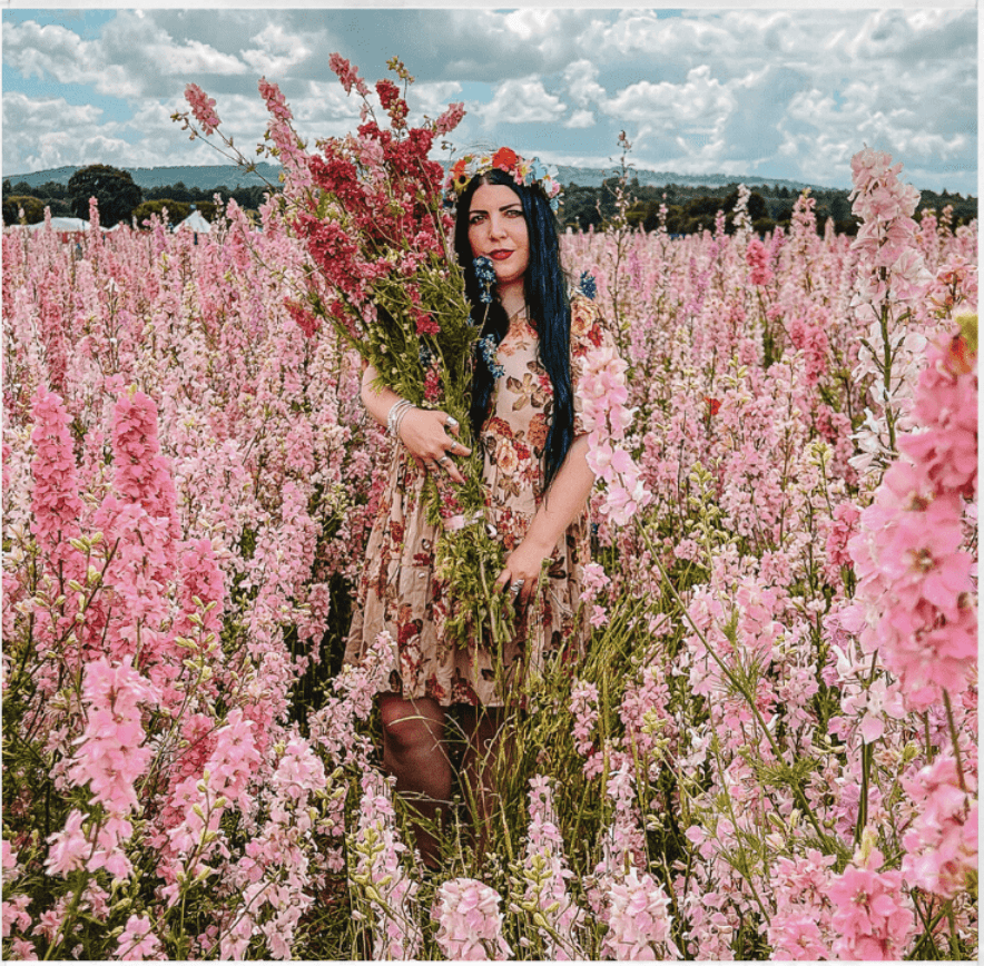 Woman standing in field of pink flowers