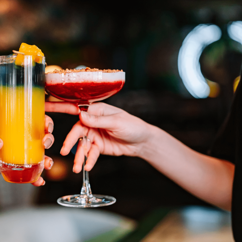 woman holding cocktail glass cheers