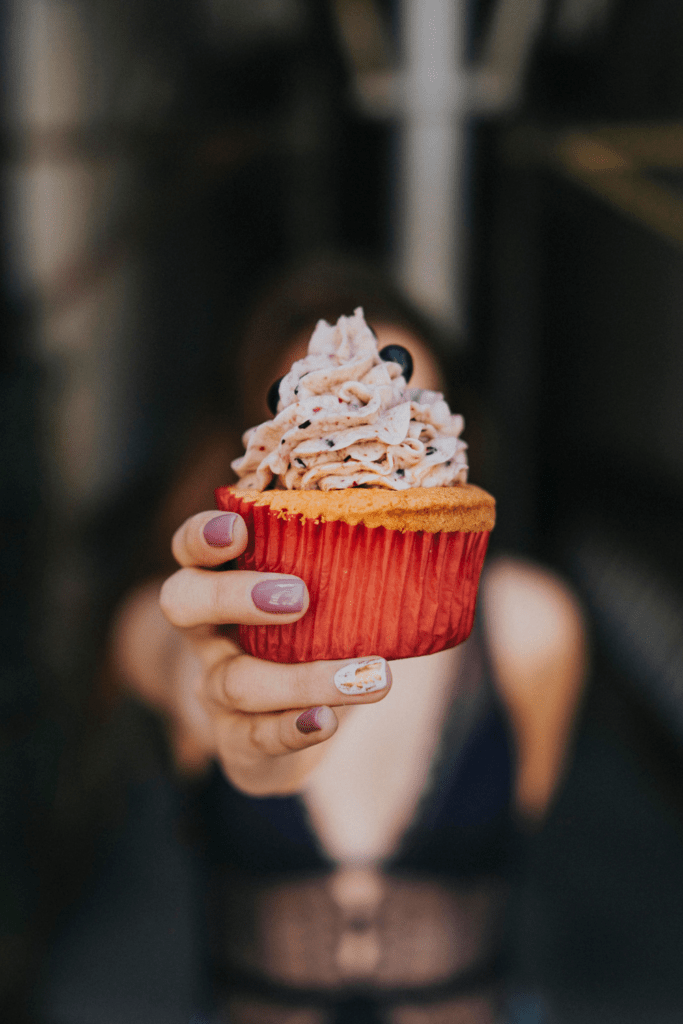 woman holding delicious cupcake